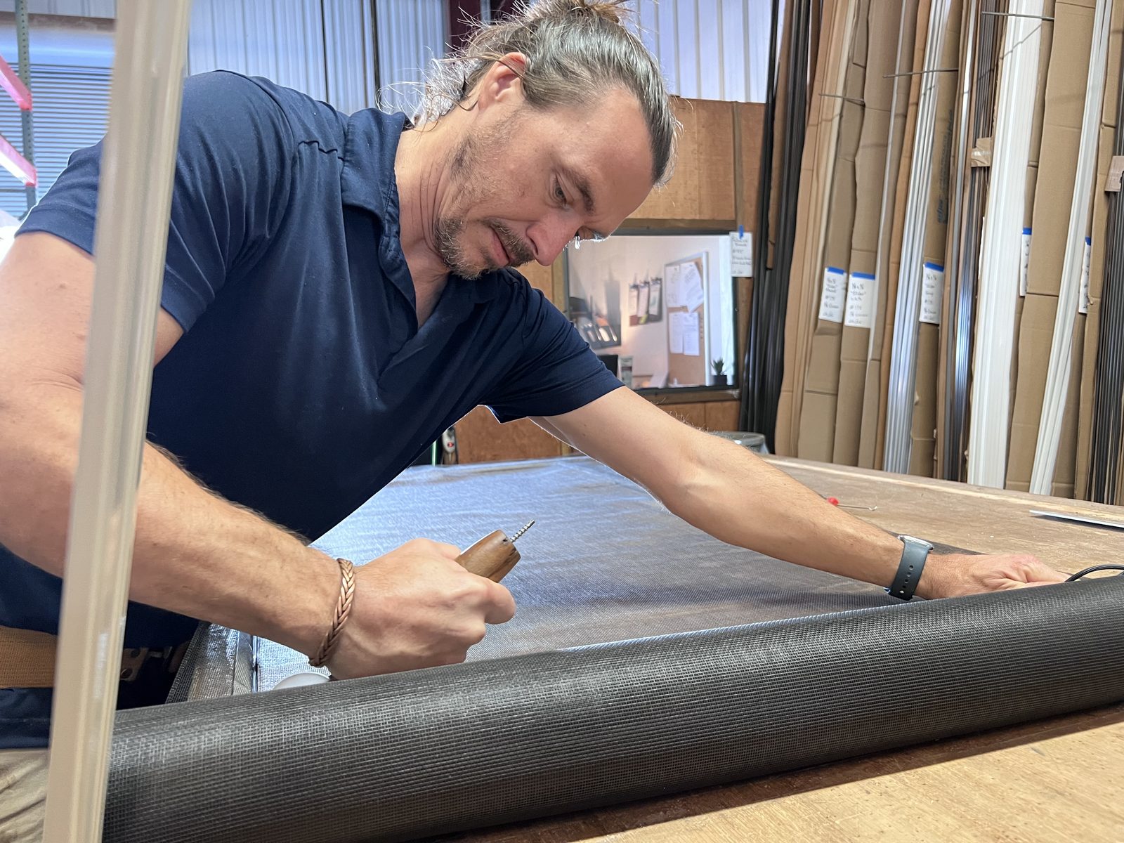 Ben Hunt spline-rolling mesh into a large screen frame