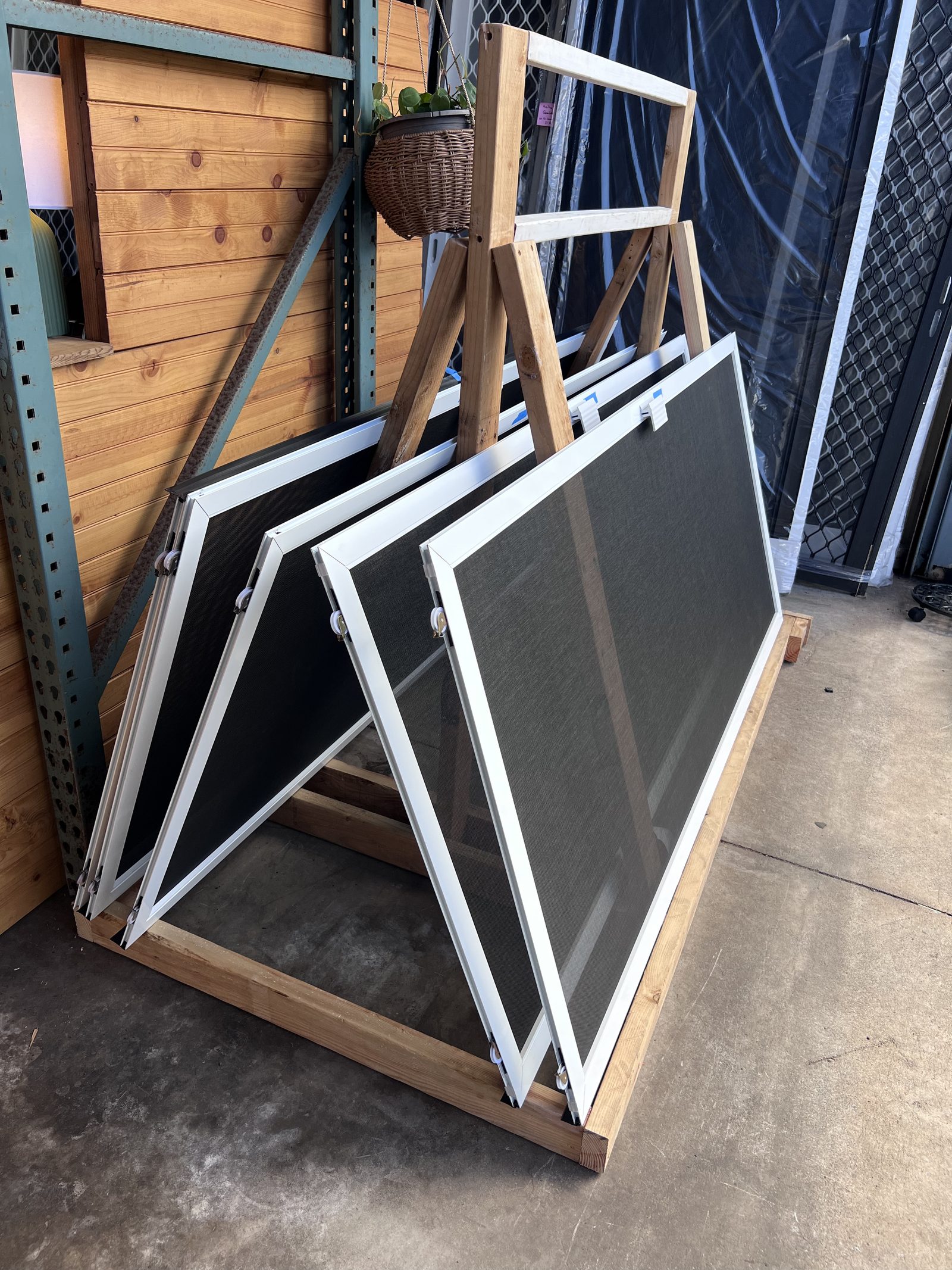 Finished custom screens resting on an A-frame rack in the shop
